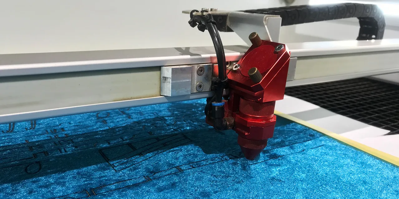 Trotec laser cutter engraving precise design on blue fabric with CO₂ laser technology