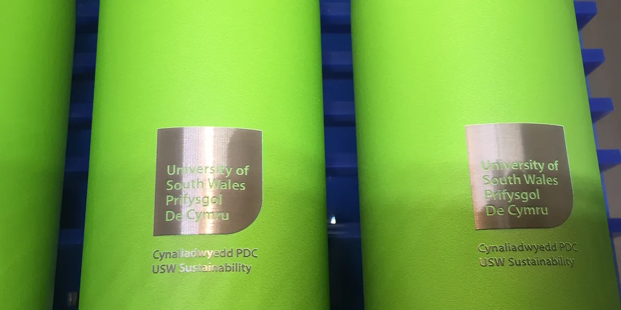 Green metal bottles laser marked with University of South Wales logo using Trotec laser engraving technology