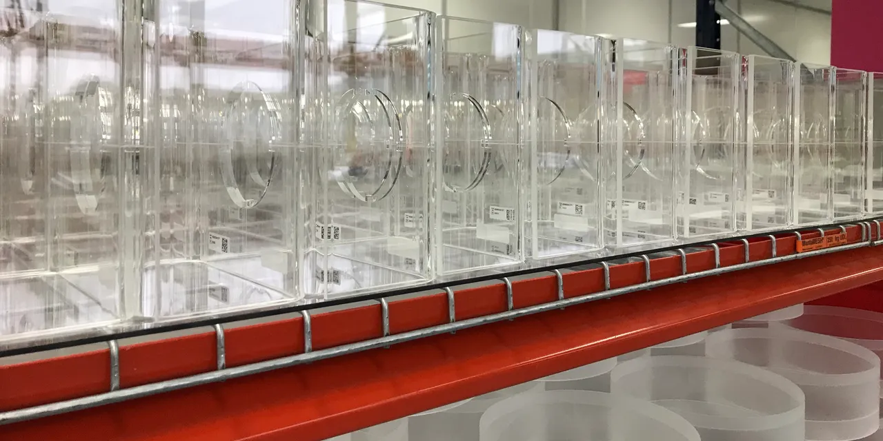 Laser-cut acrylic components for Trotec laser cutter displayed on industrial shelving
