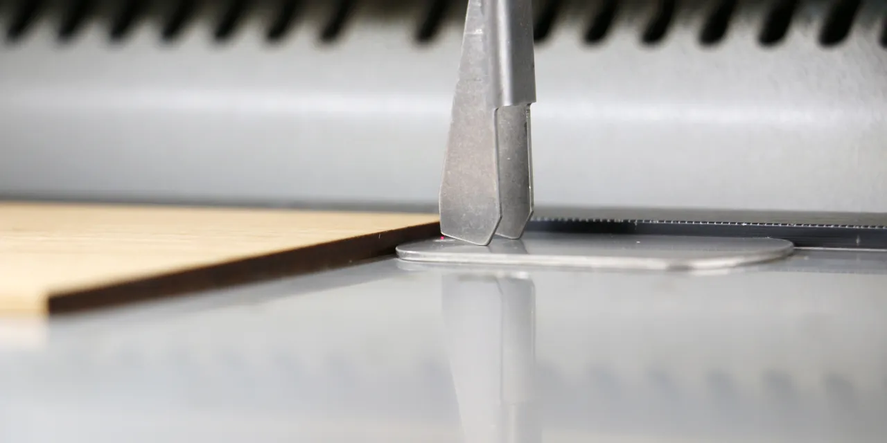 Close-up of Trotec laser cutter focusing on wooden sheet for precise engraving