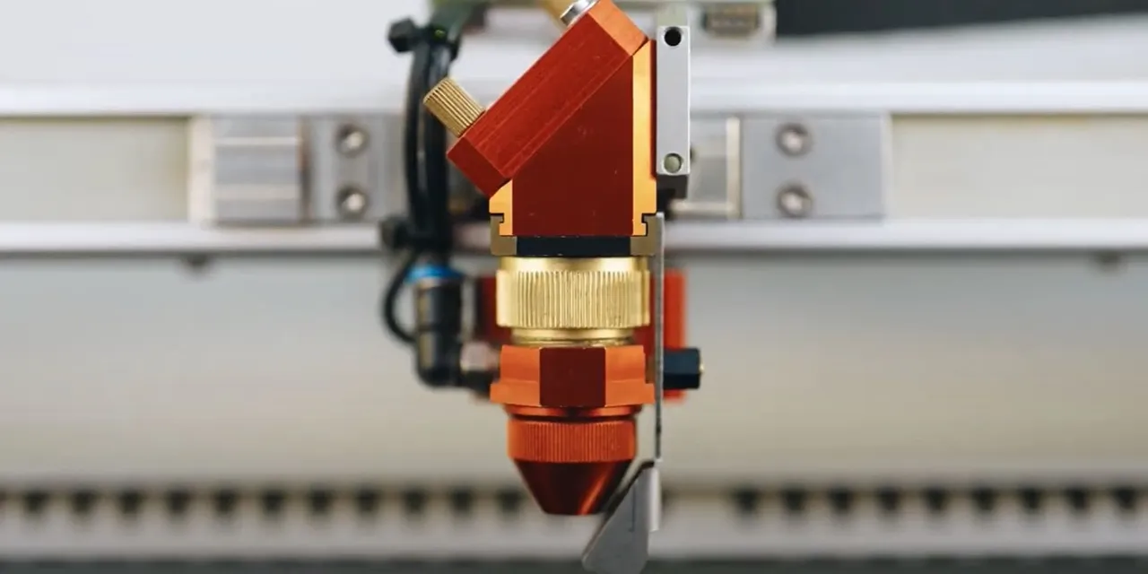 Close-up of Trotec Speedy series CO₂ laser cutter head for precision engraving and marking
