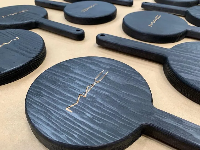 Laser-engraved black wooden hand mirrors with MAC logo using Trotec CO₂ laser cutter