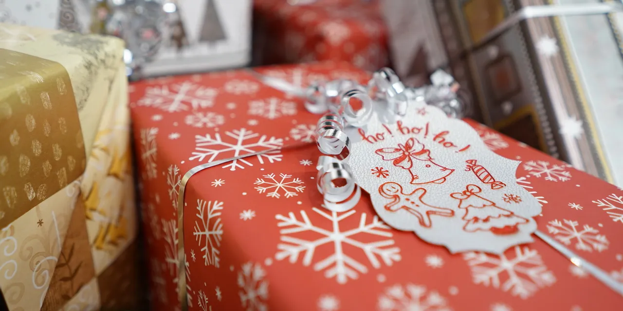 Holiday gift wrapped with snowflake paper and Trotec laser-engraved Christmas tag