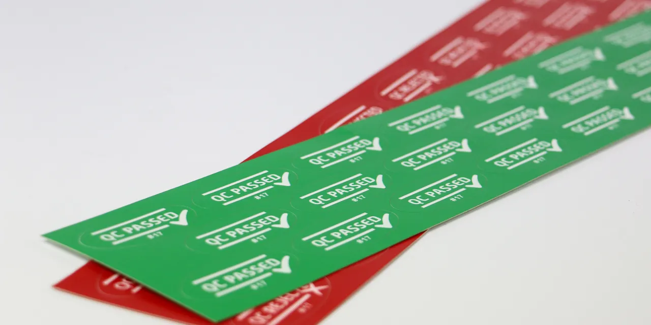 Laser-cut QC passed labels created with Trotec laser cutter on green and red adhesive sheets