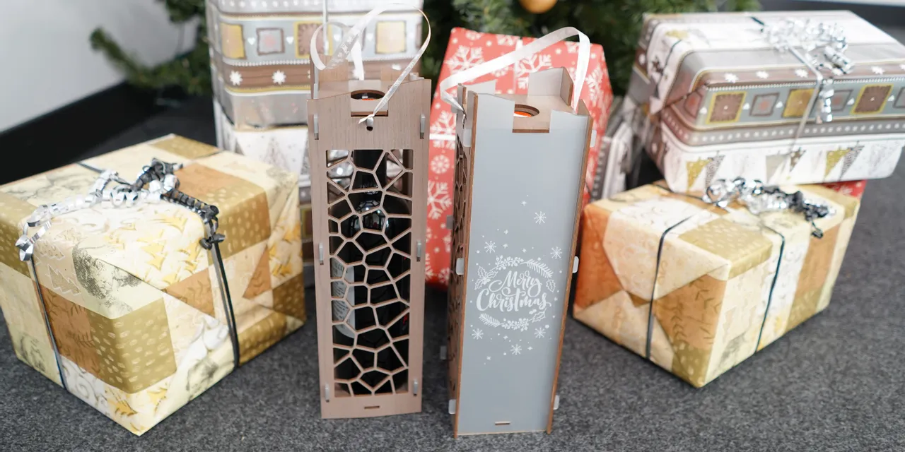 Laser-cut wooden wine gift boxes made with Trotec CO₂ laser in front of Christmas presents