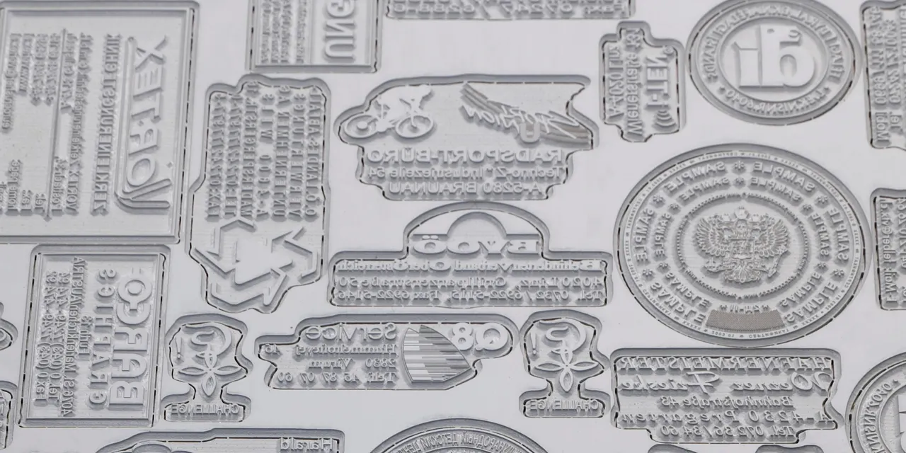 Laser-engraved rubber stamps created with Trotec laser cutter showing detailed text and logo designs