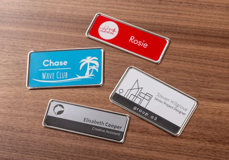 Custom name badges engraved with Trotec laser cutter on wood background