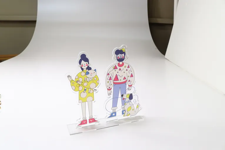 Laser-cut acrylic stand featuring colorful cartoon family figures made with Trotec laser cutter