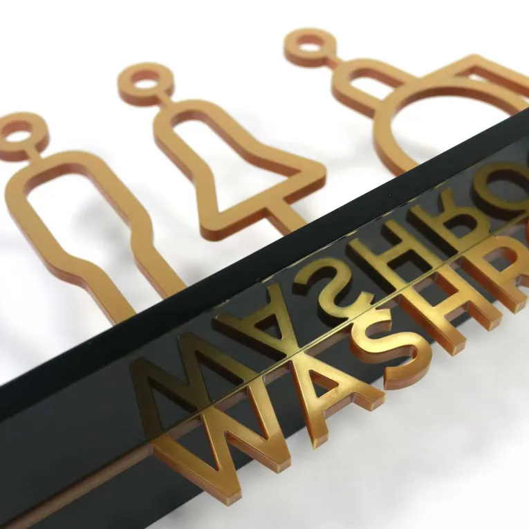 Laser-cut restroom sign made with Trotec Speedy CO₂ laser engraver using gold and black acrylic