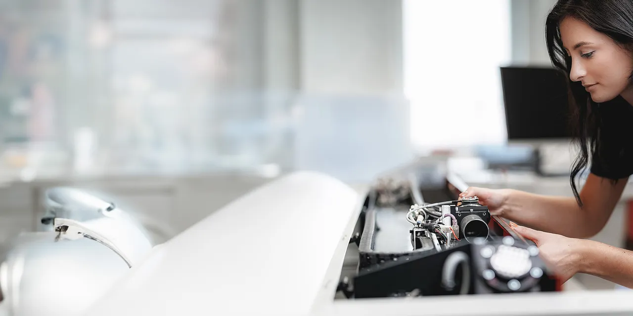 Technician working on Trotec laser cutter from Speedy series in modern workspace