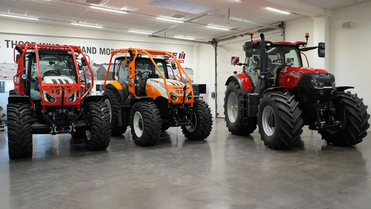 Three heavy-duty forestry and agricultural tractors displayed indoors with Steyr and Case IH branding