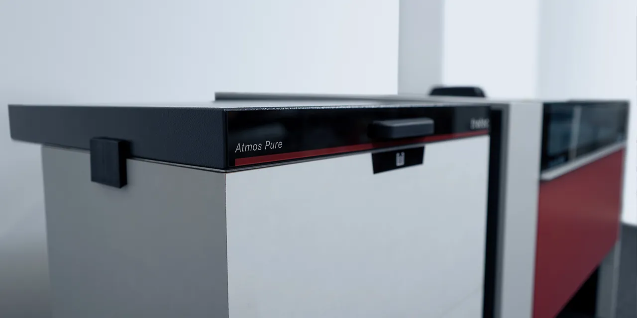 Trotec Atmos Pure exhaust system next to Speedy series laser cutter