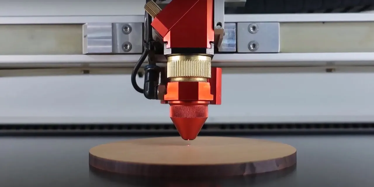 Trotec CO₂ laser cutter engraving circular wooden piece with precision head
