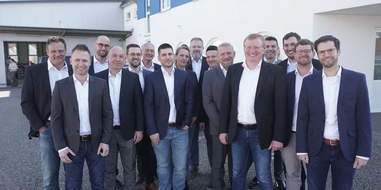 Trotec laser team members standing outside company building in business attire