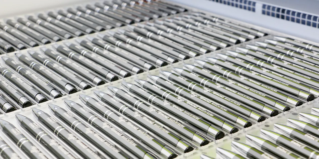 Trotec Speedy series laser engraver marking multiple metal pens in a single batch