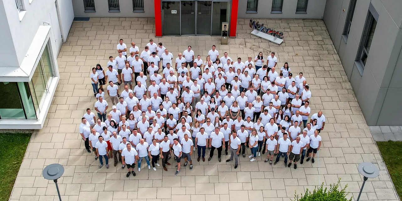 Trotec team group photo outside company building, celebrating laser technology innovation