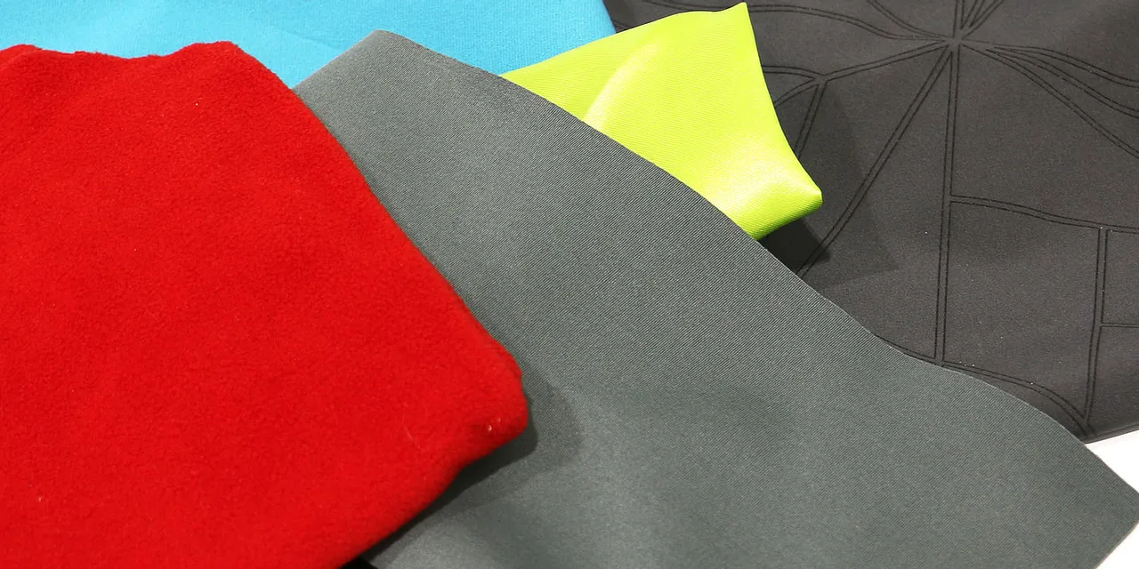 Various textiles including laser-engraved fabric samples processed with Trotec CO₂ laser cutter