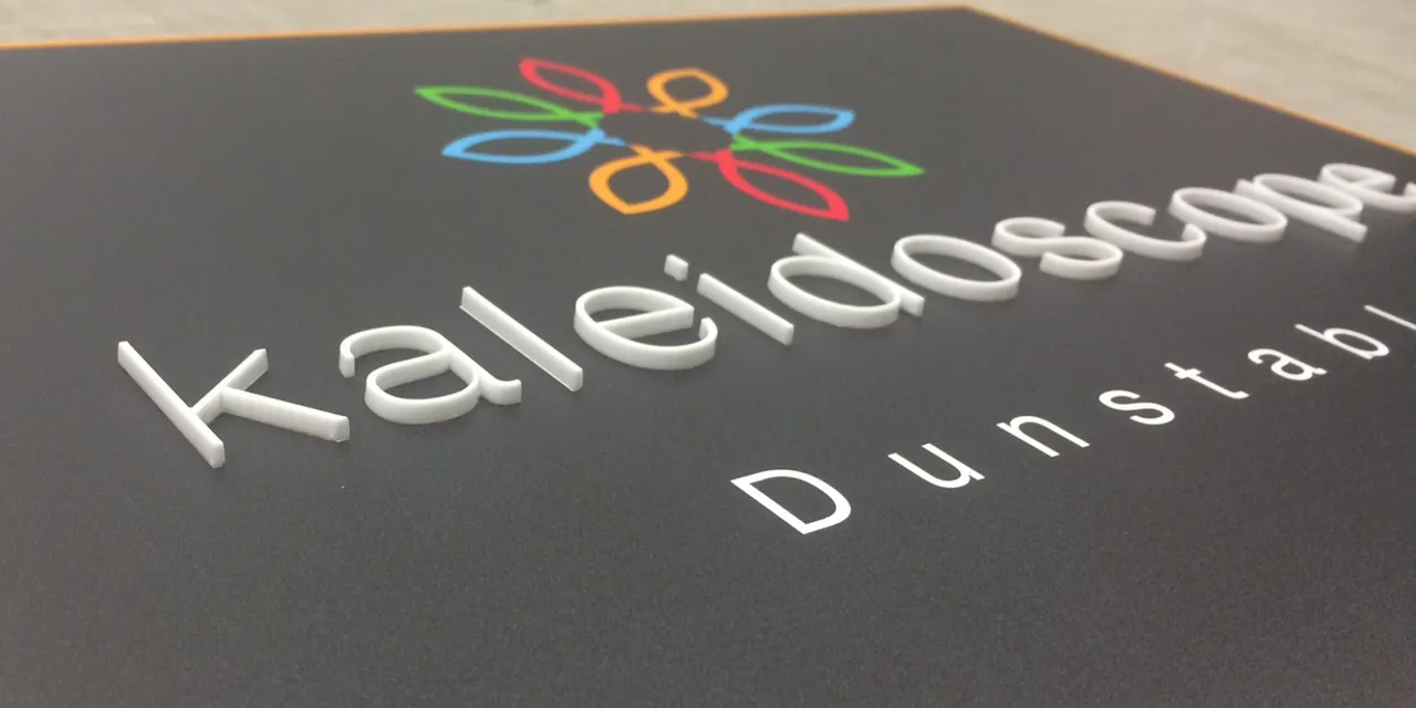 Laser-cut acrylic letters on black sign created with Trotec laser engraving machine