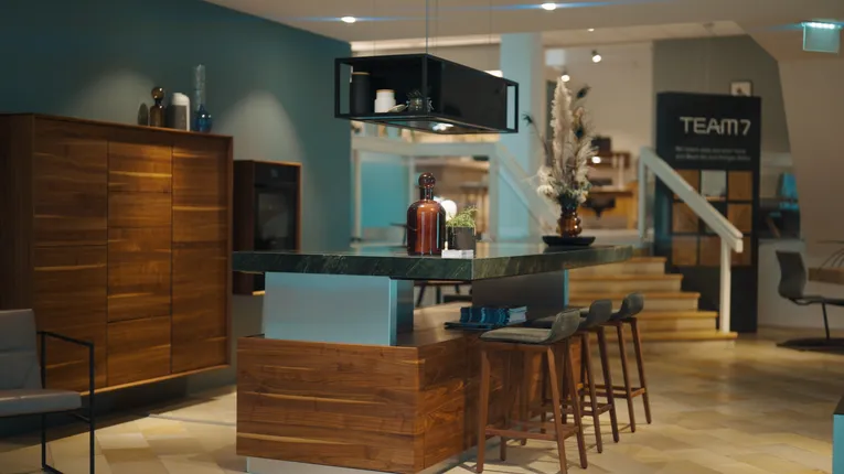 Modern kitchen showroom with wooden cabinets and island, TEAM 7 furniture on display