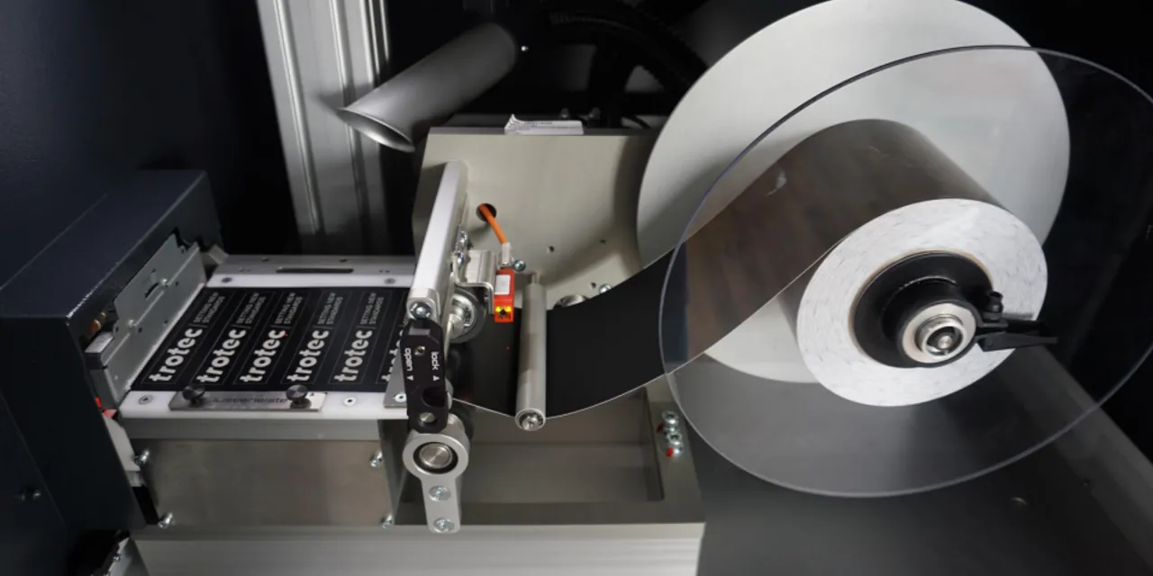 Trotec laser marking system processing industrial labels from automatic roll feeder
